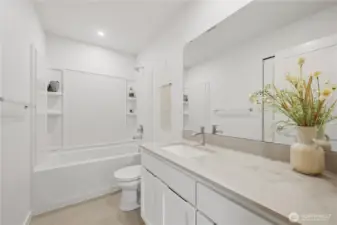 Main full bath adjacent to bedrooms 2 & 3 with quartz counters