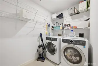 Laundry room with added storage shelves next to full bath