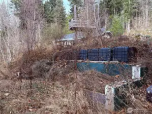 Property features a pre-existing foundation ready for a greenhouse or ADU, complemented by extensive water storage systems throughout. Secondary dwelling plans for this foundation included.