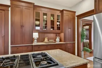 Very useful coffee bar with glass fronted cabinets and a tall cabinet for brooms and vacuum to the left.