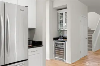 Convenient coffee station and bar prep area with wine refrigerator. Lovely glass cabinetry offers additional storage.