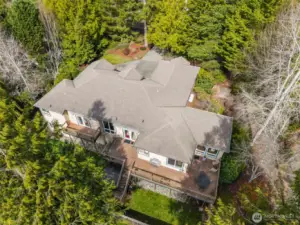 An aerial view highlights the native trees and landscape surrounding this beautiful half-acre property .