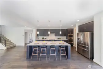 Chef's kitchen features a big island and sleek quartz countertops