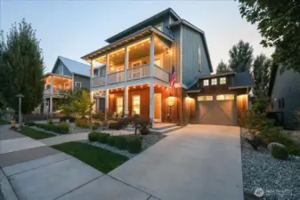 Exterior twilight view of front of home with covered porch and 1 car garage.