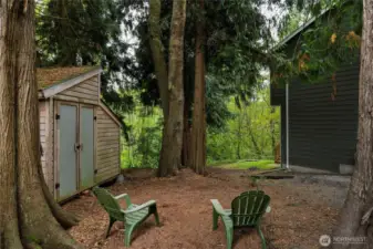 The outbuilding has been used for storage or a chicken coop. Enjoy the mature cedar trees in a park like setting.