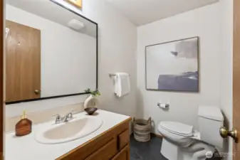 Bright main-level bathroom featuring a full tub/shower combo, extra shelving for storage, and a clean, neutral design.