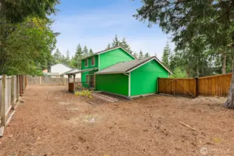 Expansive, fully fenced backyard offering ample room to play, garden, or create your ideal outdoor retreat. Mature evergreens frame the space for added privacy and a peaceful natural backdrop. A side gate provides convenient access, and the covered back porch extends your living space for year-round enjoyment.