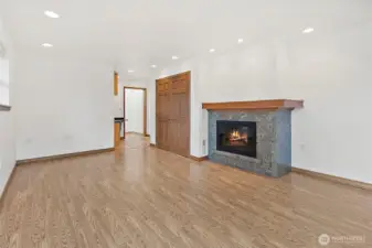 Living room/bonus room with see through wood fired fireplace to family room.