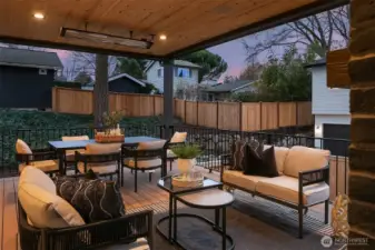 Covered outdoor living area equipped with overhead heaters, providing comfortable, year-round enjoyment for dining and lounging.