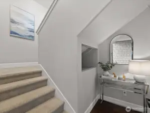 Entry staircase with vaulted ceiling, carpeted stairs, and interior landing with hardwood flooring