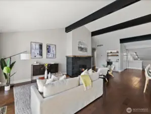 Living room with vaulted ceilings, exposed beams, hardwood floors, and open-concept layout