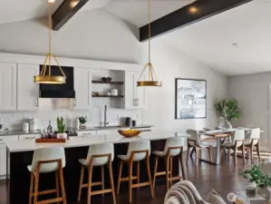 Kitchen with quartz countertops, island seating, tile backsplash, and adjacent dining area under vaulted ceilings