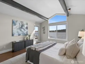 Primary bedroom with vaulted ceilings, large windows, and direct Lake Sammamish views with access to exterior deck