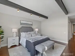 Bedroom with vaulted ceilings, hardwood flooring, and adjacent hallway access