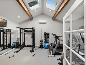 Community fitness room with exercise equipment, skylights, and vaulted ceilings