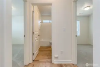 hallway facing full bath and secondary bedrooms