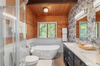 The recently remodeled primary bath features a vessel tub and new vanity with double sinks and a quartz counter top.