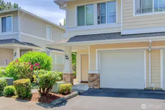 Front view of unit's garage with front door access on the left.