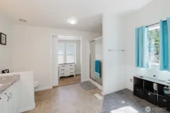 Huge primary bathroom! The area to the right is plumbed for a bathtub if you wish! Barn door is open to see the walk-in closet