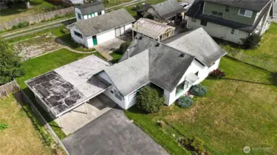Aerial capturing home,greenhouse, detached workshop, and shed