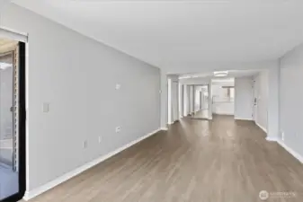 Enjoy vinyl plank flooring throughout the condo.    This picture is looking back from living room to dining room and to kitchen.