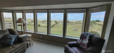 Wall of windows overlooking the deck, beach and Pacific ocean