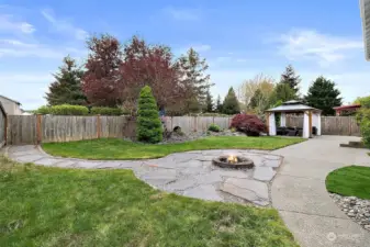 Beautiful back yard with fire pit and gate access to the neighborhood park