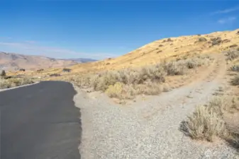 Looking North from the maintained, paved road. Driveway to the property is on the right.