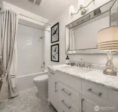Guest bathroom with marble floors and marble vanity countertop.