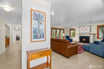 Entry reveals light-bathed living room and radiant-heated tile floors. Hallway on left offers storage on both sides; it leads to the kitchen/bedrooms and back around to living room.