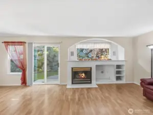 Cozy inviting open concept living & dinning features a gas fireplace. The sliding door leads to a patio & landscaped backyard
