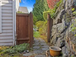 Gate & cobblestone walkway leads to the side of the condo & front yard