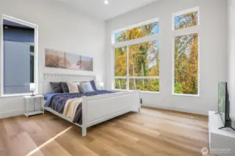 Primary bedroom with greenbelt views and vaulted ceilings.
