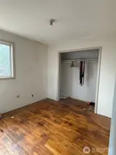 This is one of three bedrooms.  Notice the original hardwood.