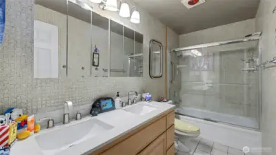 Upper-level bathroom with dual sinks and generous storage