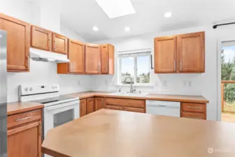 Kitchen with ample counter space, island and a window that looks out to the large backyard