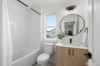 This sleek bathroom features a modern vanity, a perfectly framed mirror, and a deep soaking tub for those end-of-the-day unwinds.