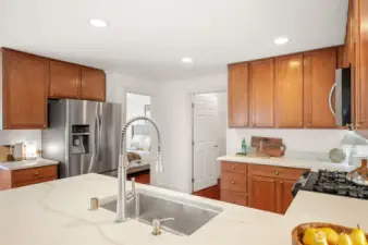 Spacious kitchen with new quartz countertops and ceiling height cabinets.