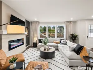 Large family room view with cozy fireplace with loads of windows. Photo is representational. Actual home is under construction and finishes and paint colors may vary. See site agent for details....