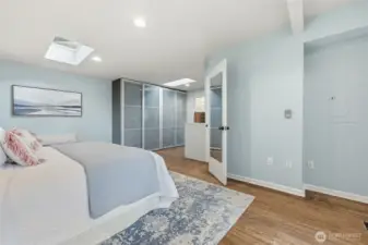 The frosted glass sliding doors seen in the center enclose your custom built closet. The mirrored door opens to your bathroom.