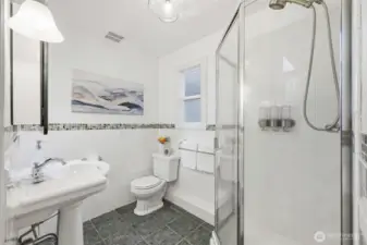 Your en-suite bathroom has a shower stall and pedestal sink.