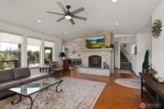 Living room with gas fireplace looks into kitchen. Front door to the right.