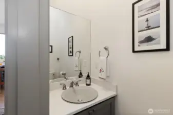 Downstairs half bath located between kitchen and stairs.