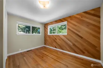 Bedroom enhanced by a stunning wood feature wall, adding warmth and character to the space.