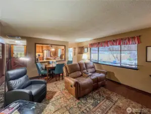 Living room with dining area and open to the kitchen and a door to the outside.