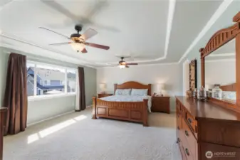 The spacious primary suite is a relaxing retreat, featuring two ceiling fans, coved ceiling, and crisp white trim. Enjoy the convenience of a walk-in closet and a private en suite bathroom for your own personal sanctuary.