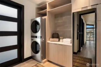 The utility room is surprisingly stylish, featuring a state-of-the-art wardrobe steamer and stunning floor-to-ceiling shelving and cabinetry. Smartly located under the breezeway and just across from the garage, it offers both function and flair the moment you come inside.