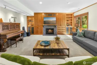 Lower-Level Recreational Room with gas fireplace, built-in ceiling speakers, back-lit bookcases and access to an additional heated patio with Mt. Rainier views.