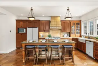 Very large custom kitchen island with reclaimed cabinets and slab granite top.