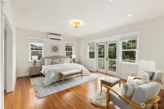 Generous primary bedroom with sitting area and french doors to private balcony.